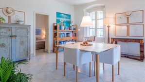 Un espace repas comprenant une table, des chaises, une lampe, une bibliothèque et un meuble.