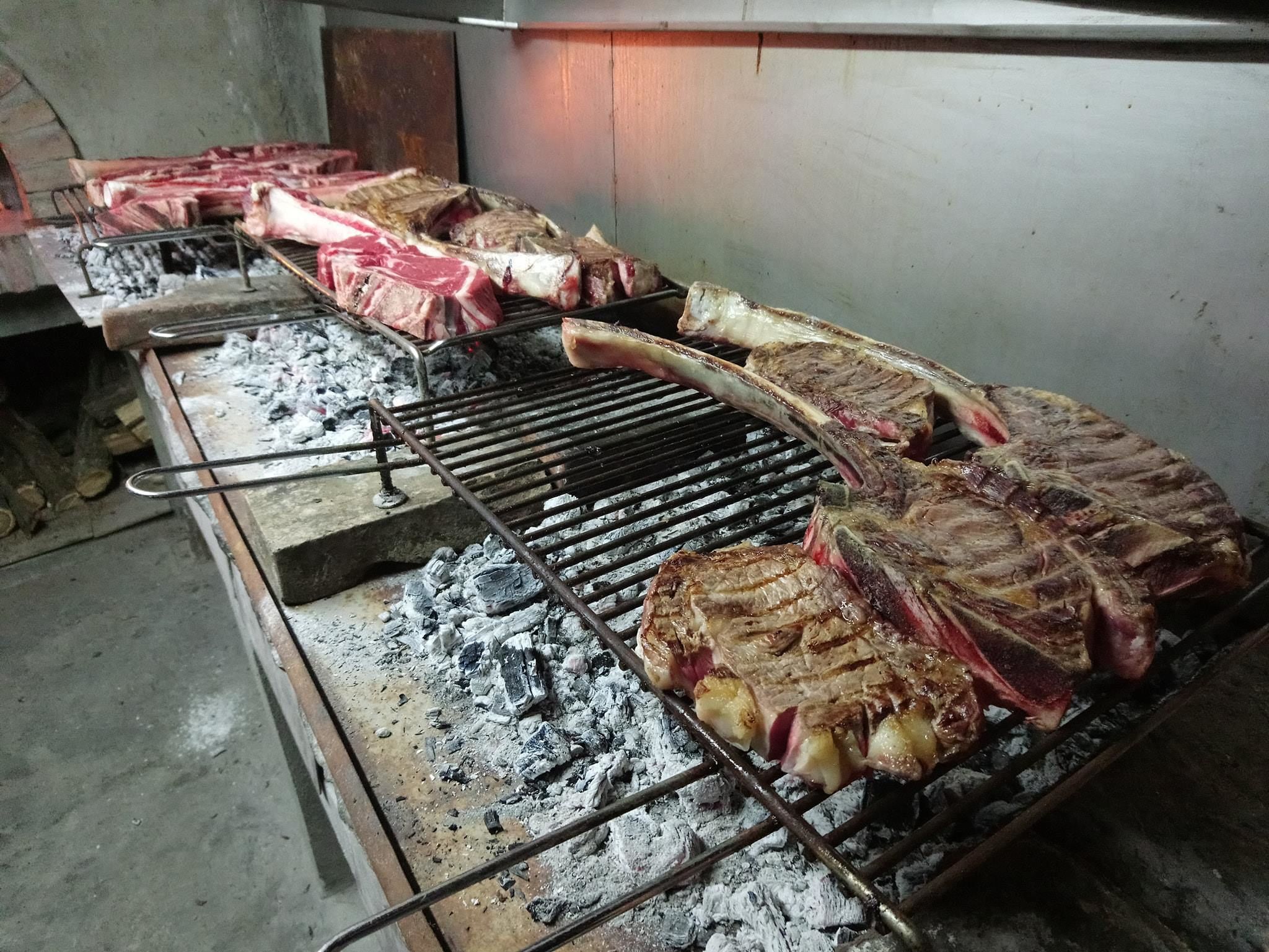 Ein Grill mit verschiedenen Fleischstücken, die gebraten werden.