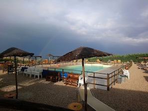 Piscina externa sazonal, funciona das 9h às 23h, guarda-sóis