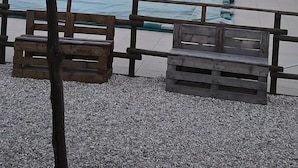 Une piscine entourée d’une terrasse en bois, dotée d’un parasol en chaume et offrant une vue sur la lune.