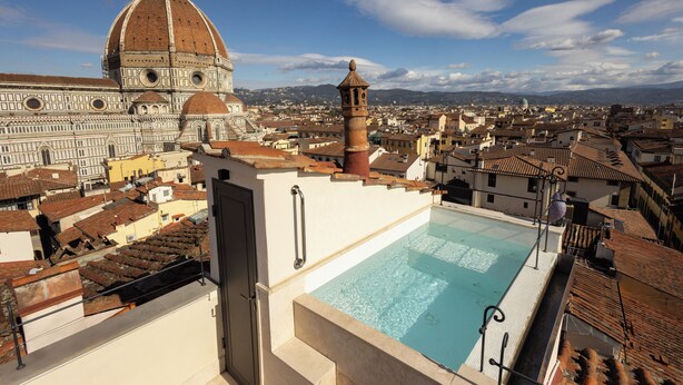 Piscina no terraço com vista para a Catedral de Florença e paisagem urbana circundante.