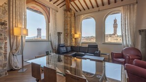 Quarto com mesa de vidro, sofá de couro e paredes de pedra.