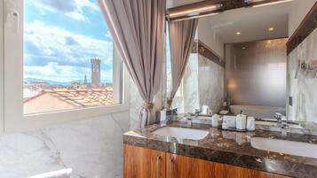 A bathroom with a large mirror, two sinks, and a view of a cityscape.