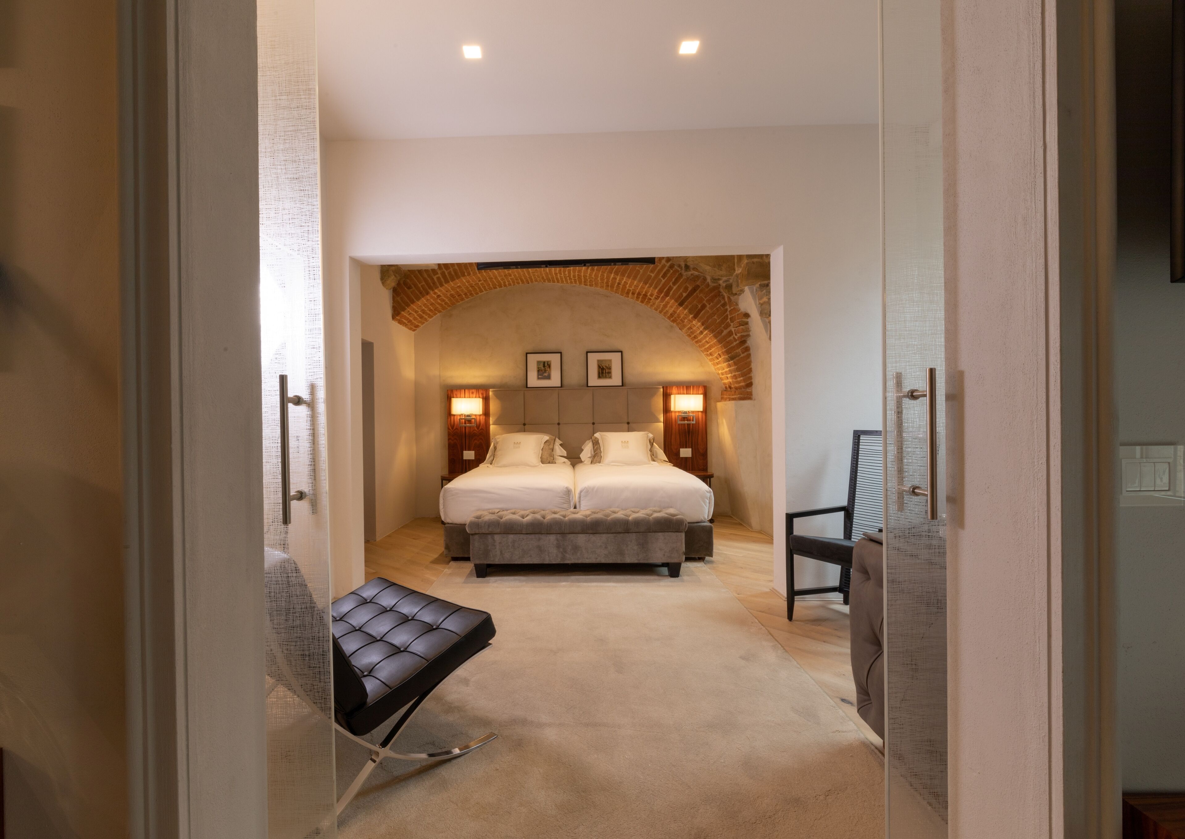 Une chambre à coucher avec un grand lit, un banc et une chaise.