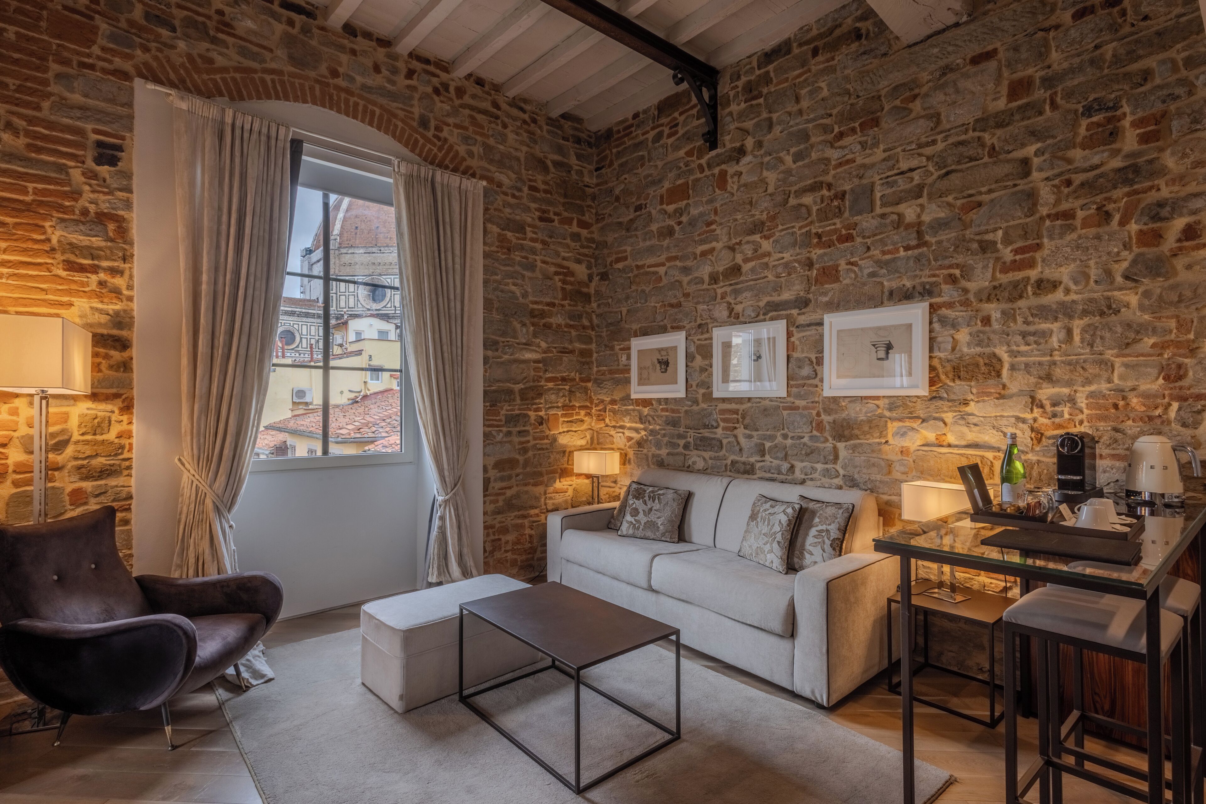 A cozy living room with a stone wall, a sofa, a coffee table, and a small bar area.