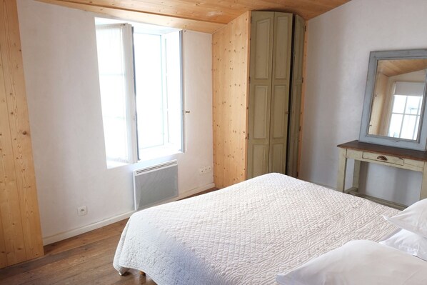 A bedroom with a bed, a dresser, a mirror, and a window. - Hôtel Le Sénéchal (Ars-en-Re)