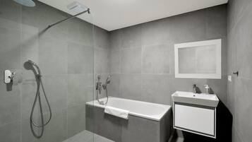 Uma casa de banho moderna com chuveiro, banheira e lavatório.