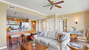 A spacious living room with a sofa, coffee table, and a dining area with chairs and a table. - Maui Resort Rentals: Honua Kai Konea 438 – Luxurious 1BR Suite w/ Upgraded Interior and Tranquil, Private Location (Lahaina)