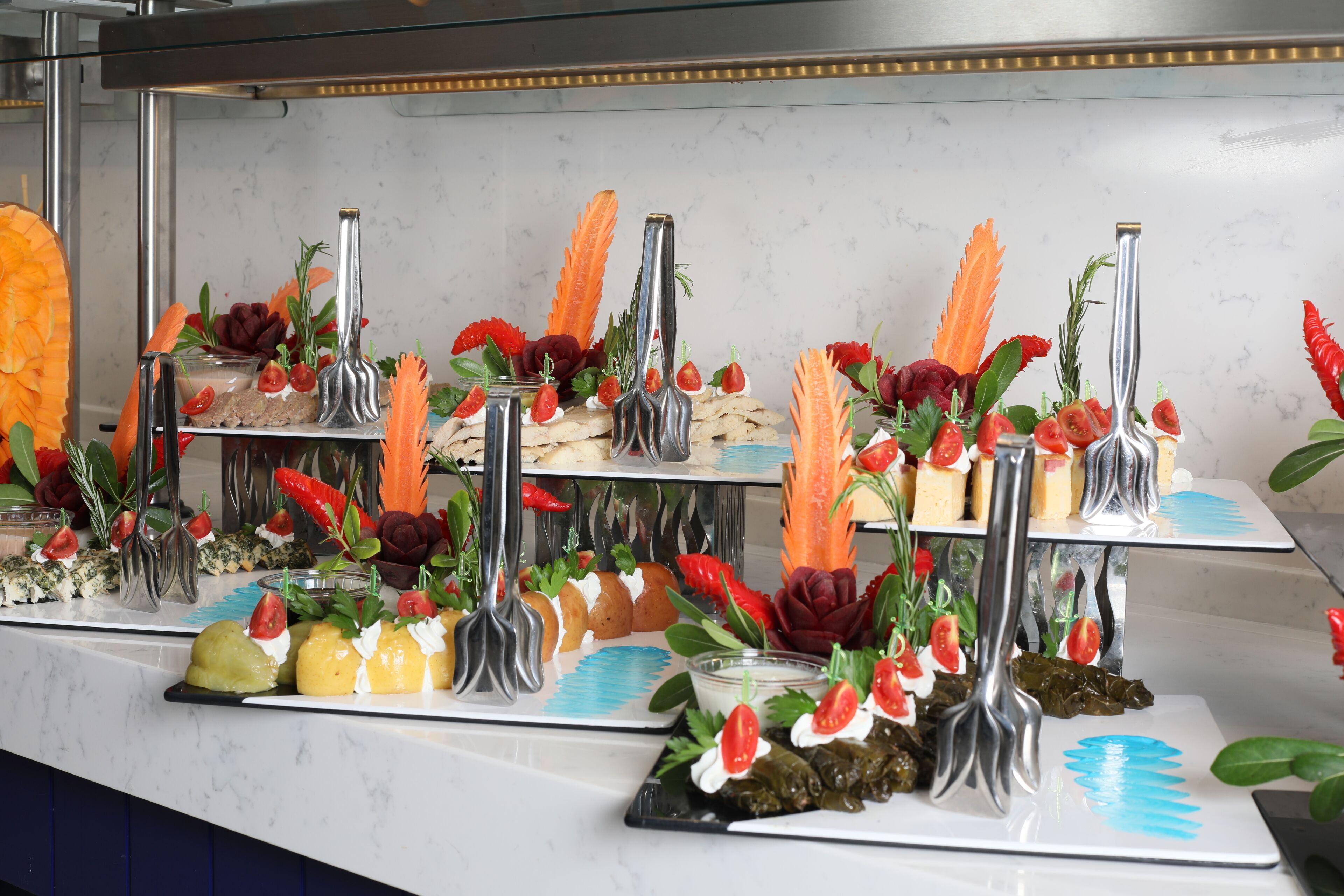 A buffet with various food items and garnishes.