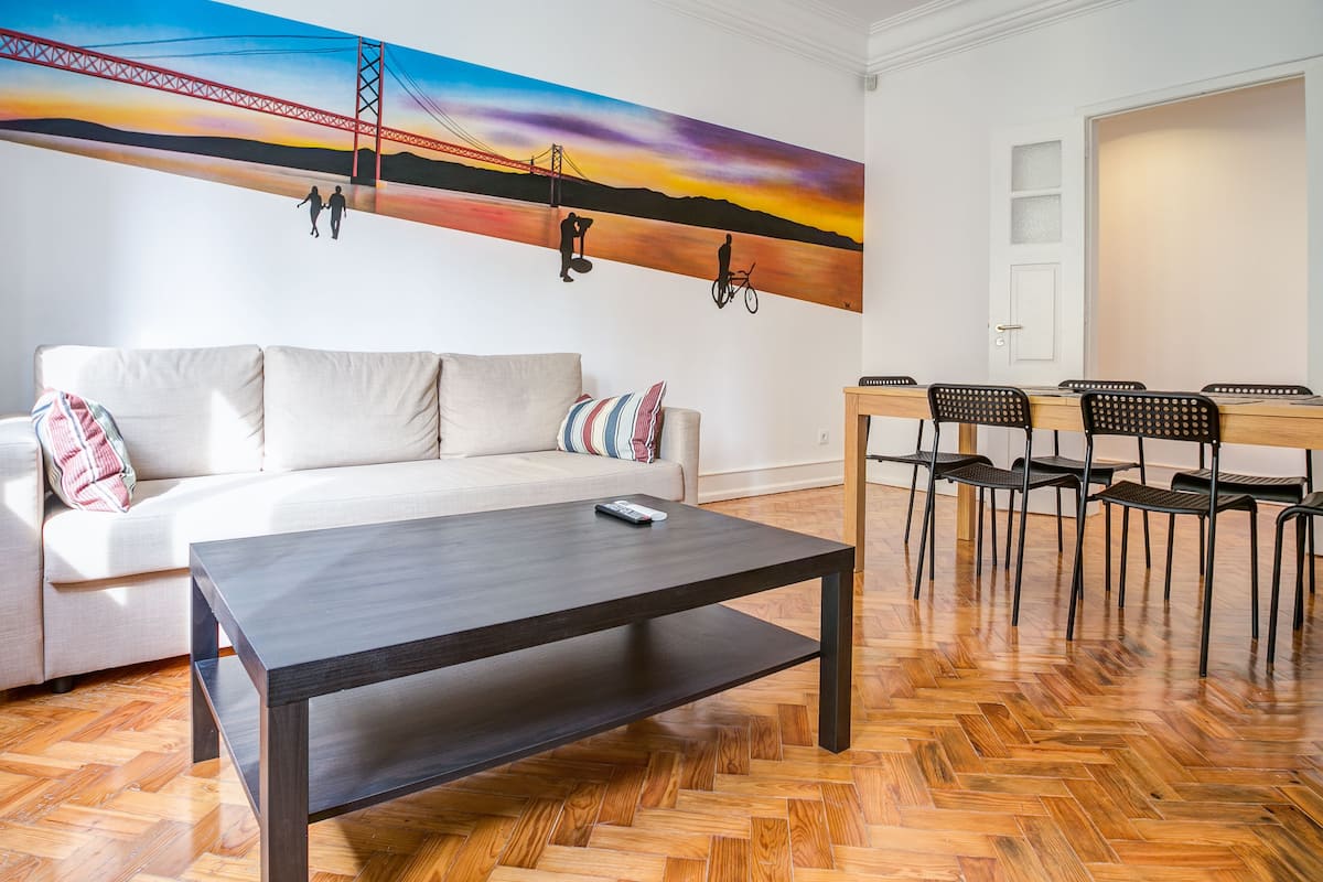Un salon moderne comprenant un canapé, une table basse et un coin repas avec des chaises et une table.