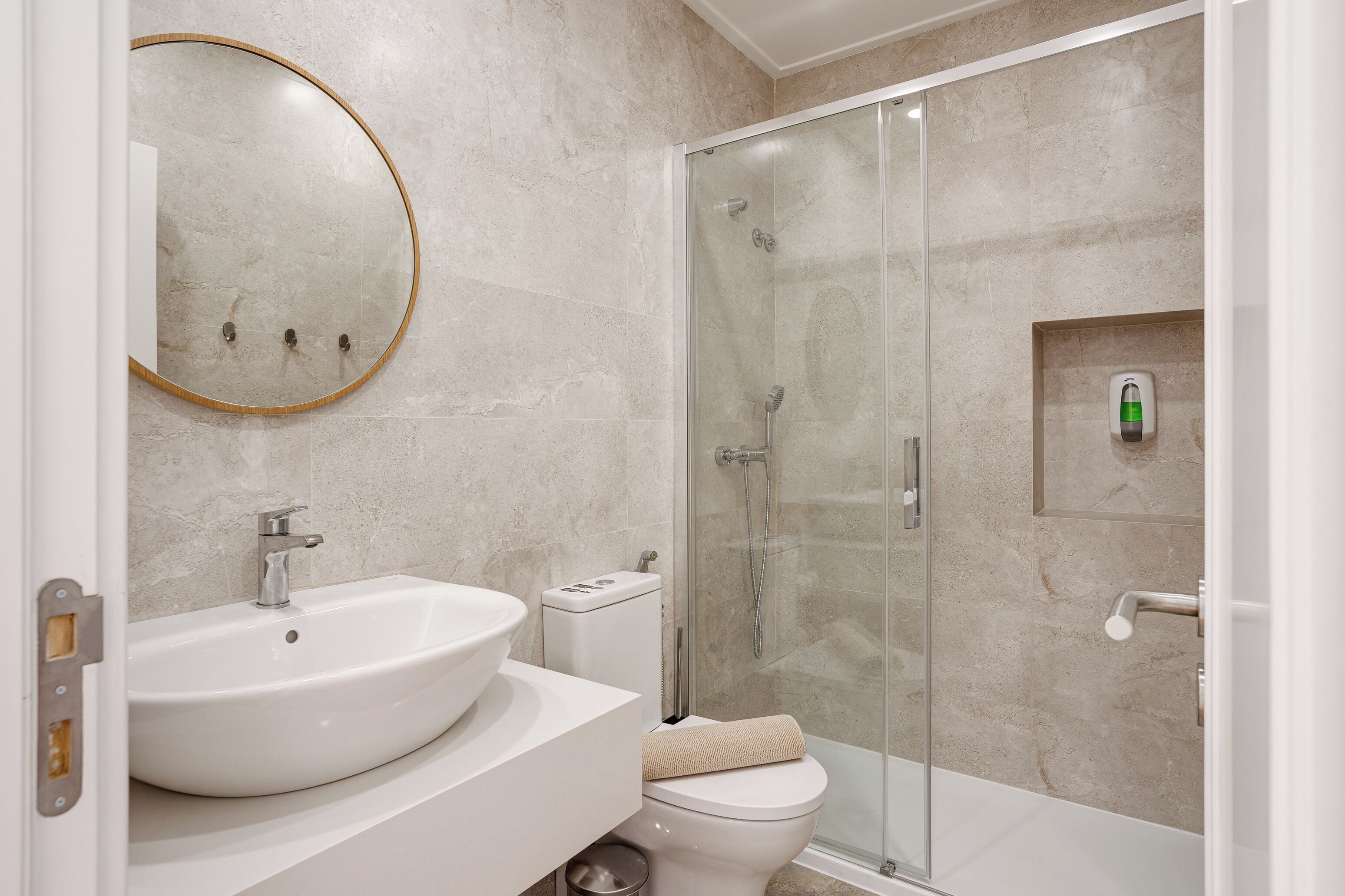Une salle de bain équipée d’un lavabo, de toilettes et d’une douche à parois de verre.