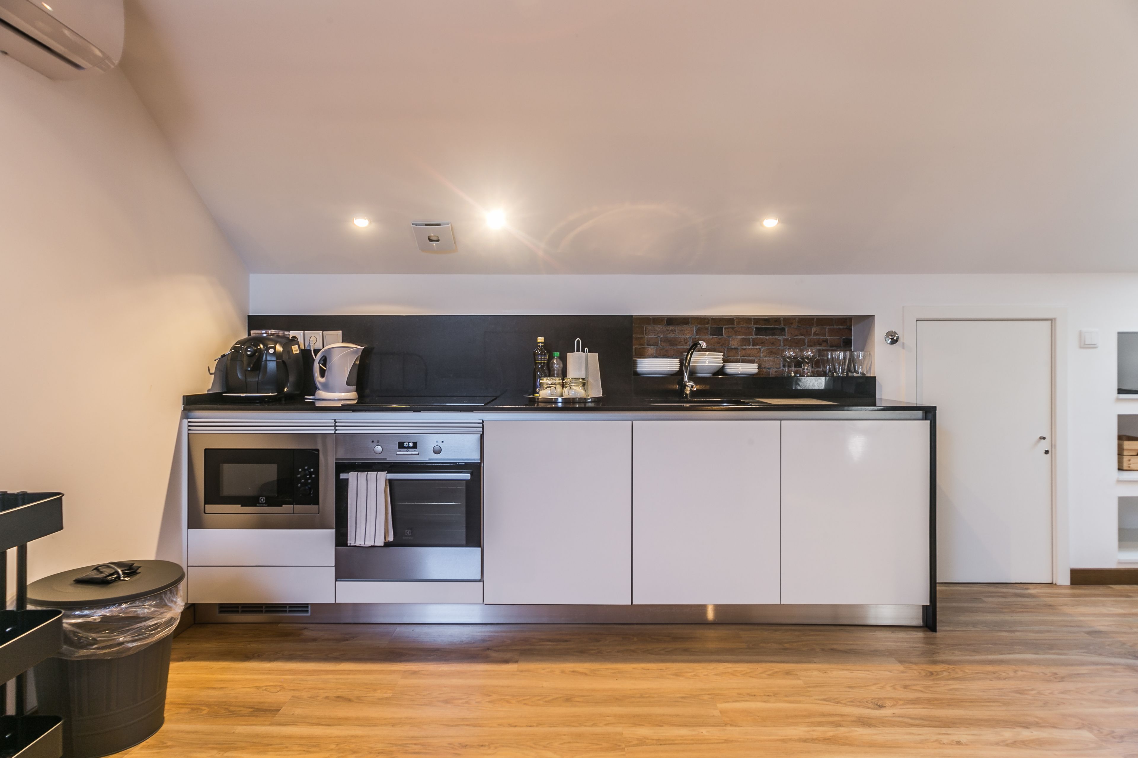 Una cocina moderna con horno empotrado, microondas y electrodomésticos de acero inoxidable.