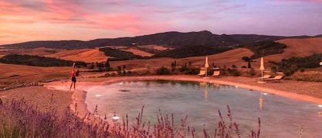 Una piscina al aire libre de temporada, sombrillas