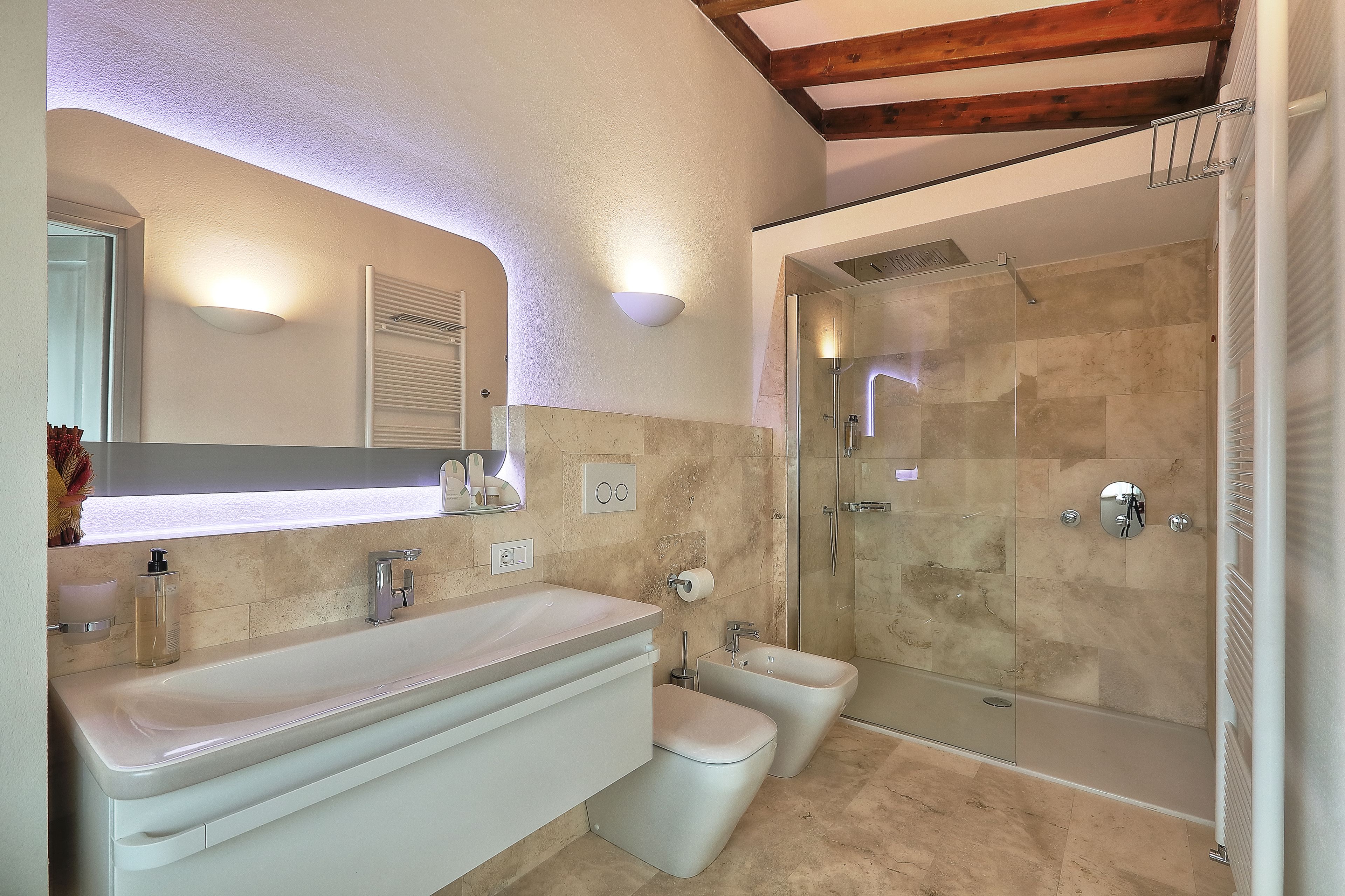 A modern bathroom with a large sink, a toilet, and a glass-enclosed shower.