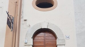 Una puerta doble de madera con marco metálico, que da a una escalera de piedra con barandilla de metal.