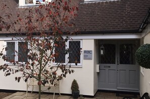 Guest accommodation with a welcoming entrance featuring a sign and a small potted plant.