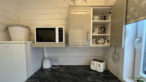 A compact kitchen with a microwave, toaster, and a small sink. - Park Farm Bed and Breakfast (Windsor)