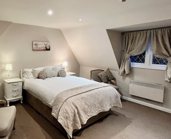 Cozy retreat with a large bed, bedside tables, and a window with curtains.