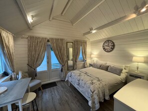A cozy bedroom with a bed, bedside tables, a clock, and a window with curtains. - Park Farm Bed and Breakfast (Windsor)