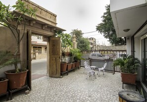 A courtyard with a tiled floor, potted plants, and outdoor furniture. - Shree Mohan Villas- Heritage Hotel (Jodhpur)