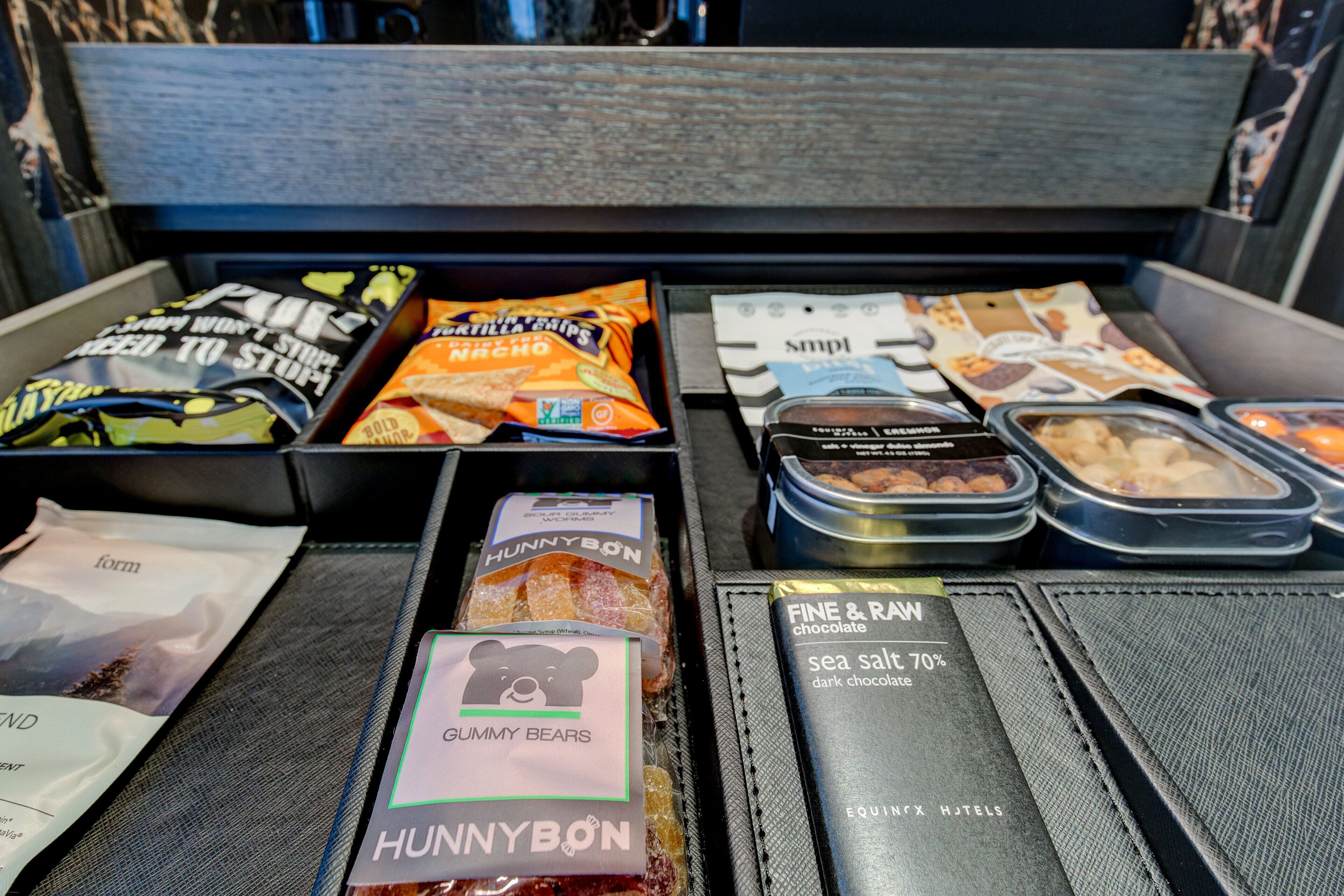 A variety of packaged snacks and desserts in a hotel minibar.