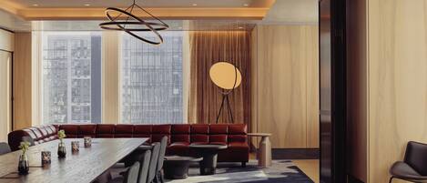 Un espace de repas moderne comprenant une longue table, des chaises, un canapé et un lampadaire.