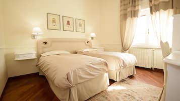 Un dormitorio con dos camas, una mesita de noche, un radiador y una ventana con cortinas.