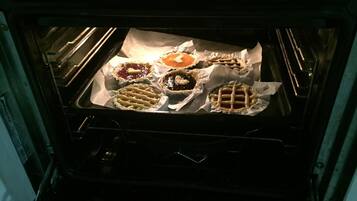 Een open oven met verschillende gebakken producten op een bakplaat.
