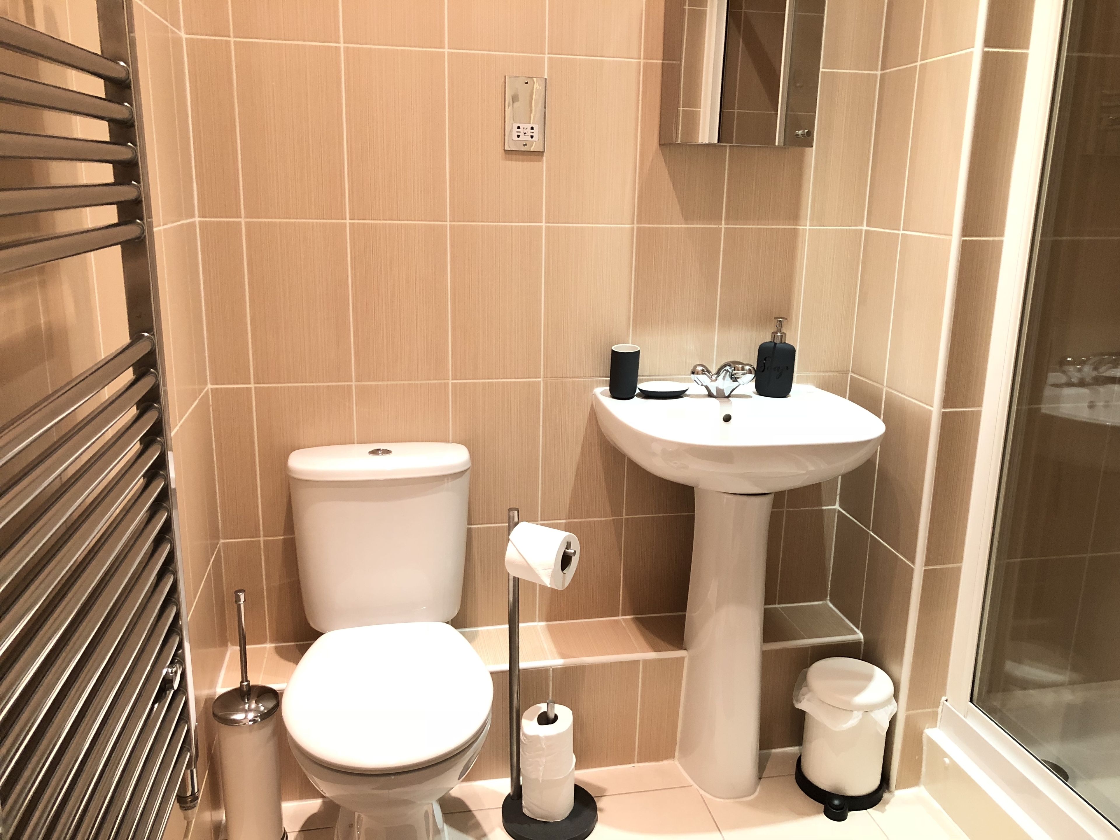 A modern bathroom with a toilet, sink, and shower.