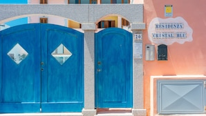 A building with a blue gate, a sign reading "RESIDENZA CRISTAL BLU", and a mailbox. - Residence Cristal Blu (Santa Teresa di Gallura)