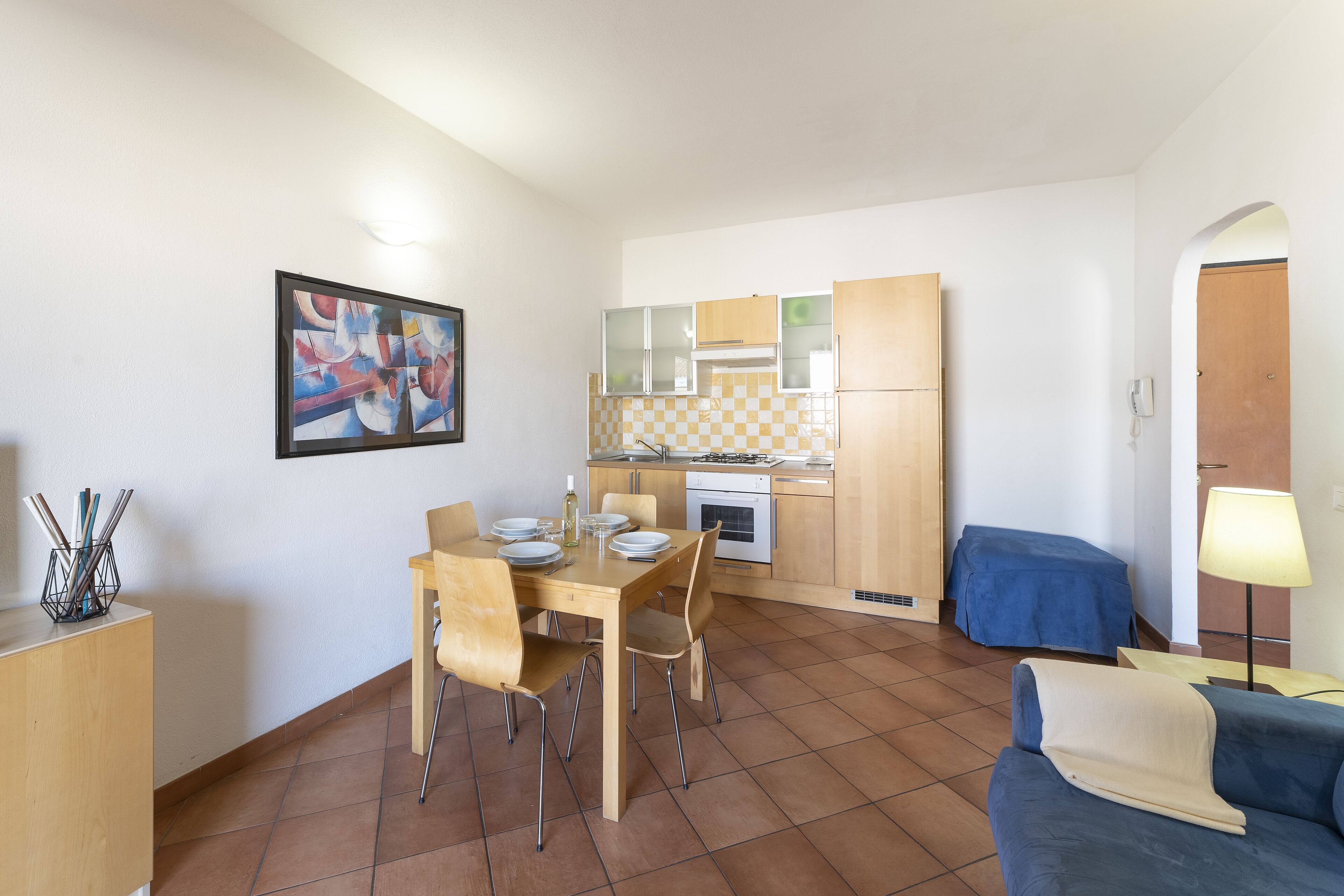 A compact living space with a dining area, kitchenette, and a sofa.