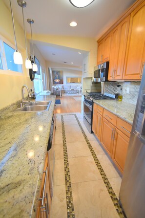 A modern kitchen with granite countertops, stainless steel appliances, and wooden cabinets.