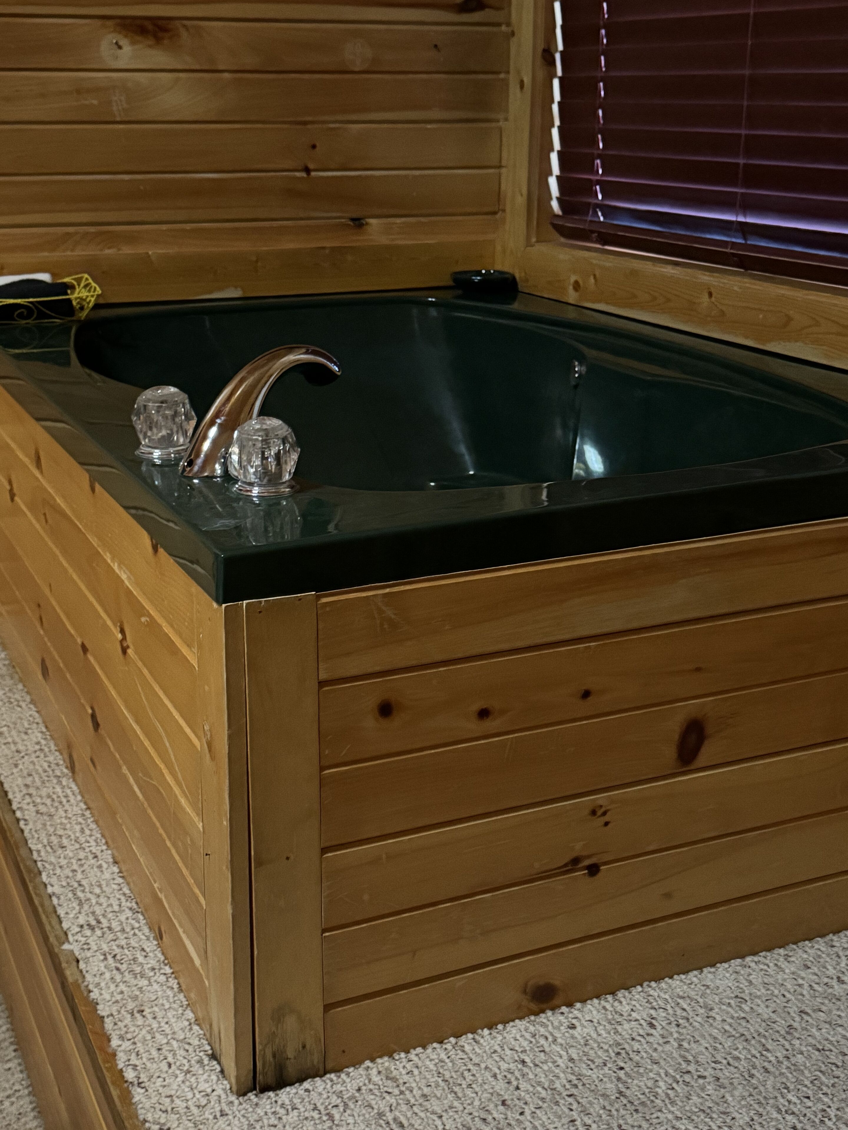 Eine hölzerne Badewanne mit Glasabdeckung und zwei Glasflaschen.