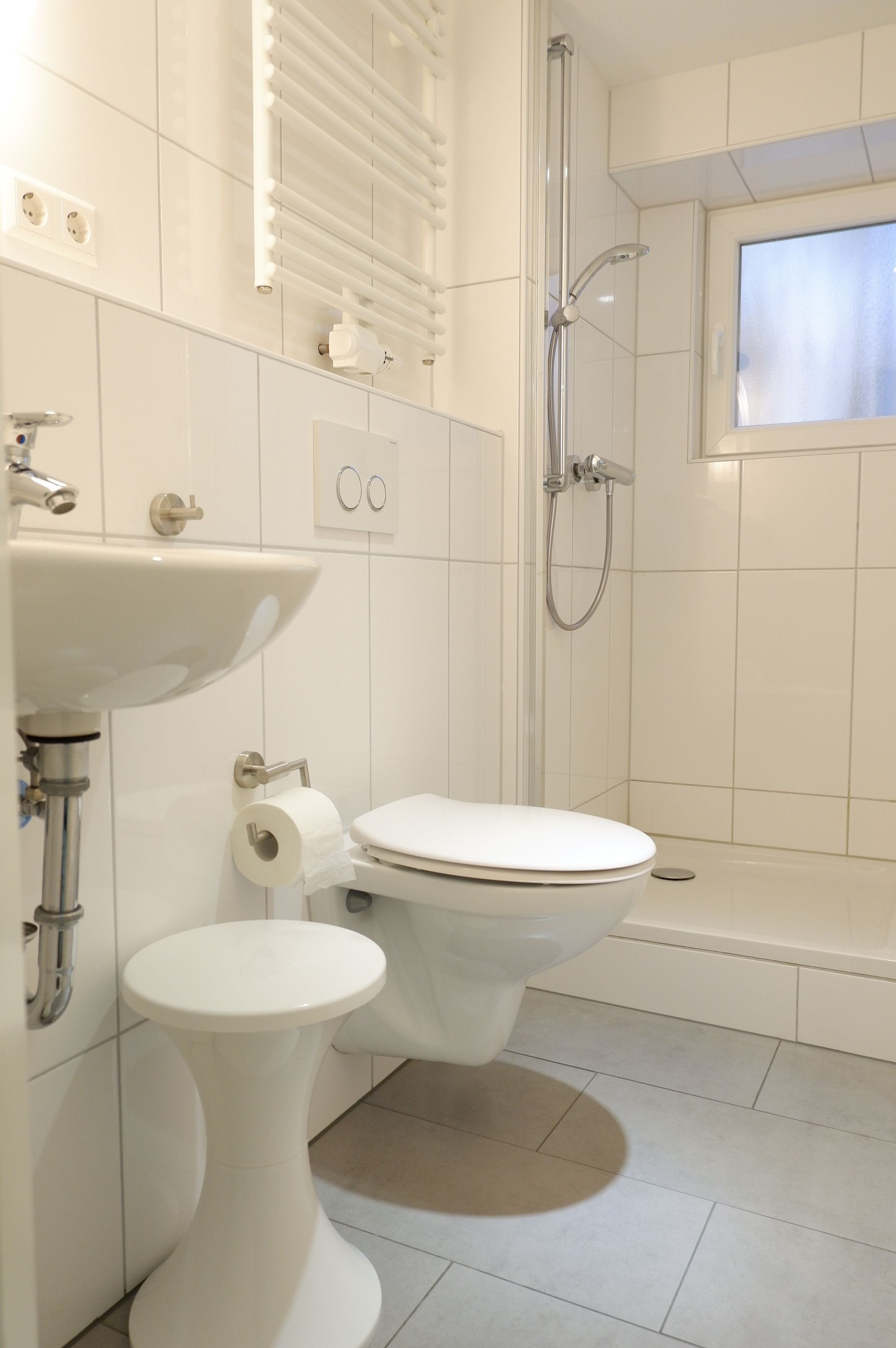 A bathroom with a toilet, sink, and shower.