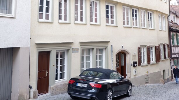 A two-story building with a car parked in front. - Apartment Zentral (Tuebingen)