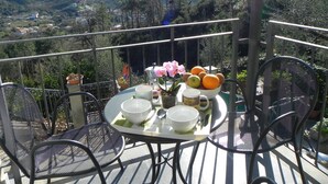 Ein Balkon mit Esstisch, mit Blick auf eine Berglandschaft.