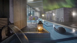 Une piscine intérieure avec un panneau indiquant qu’il est interdit de plonger et dont la température est de 34 °C.