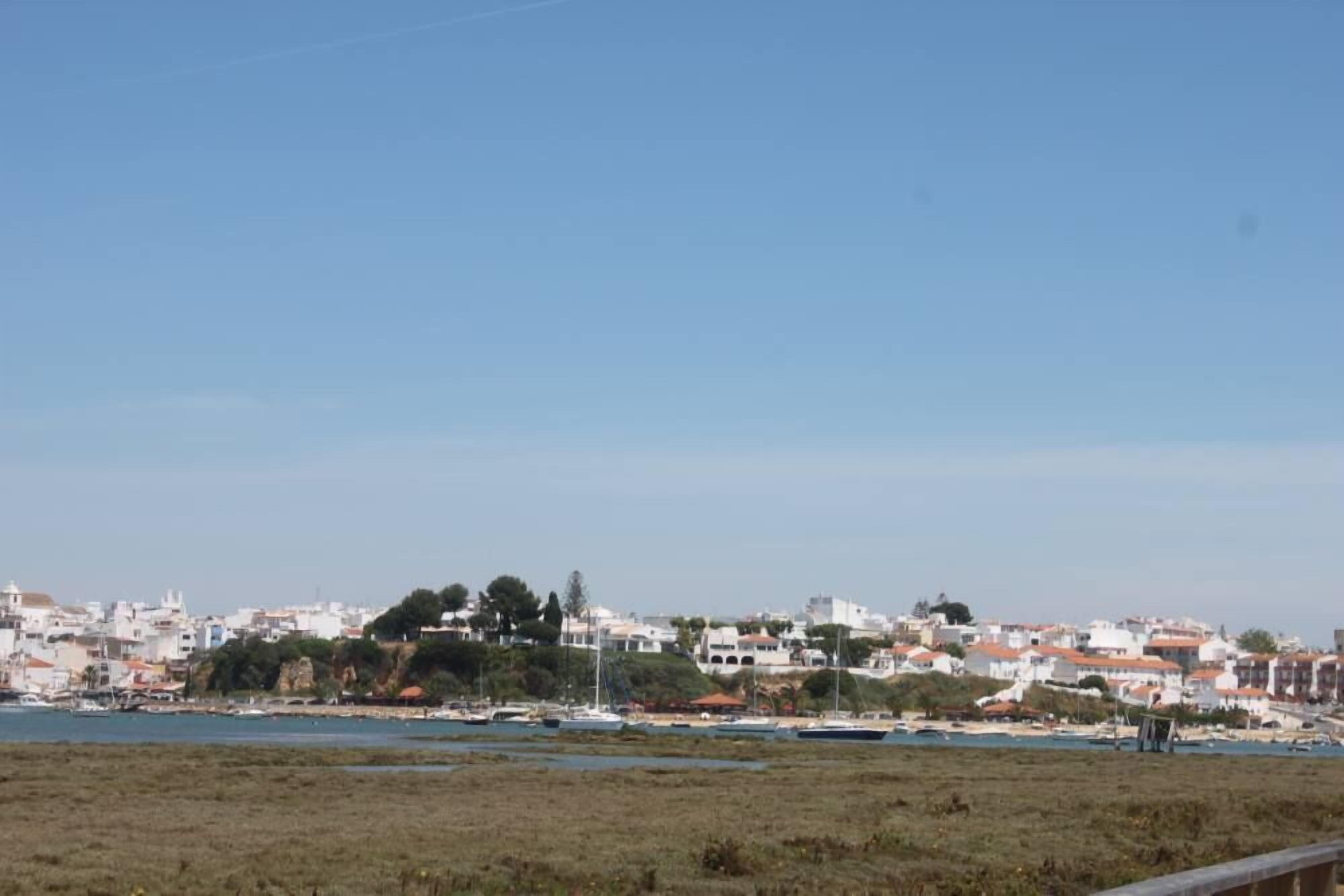 Une ville côtière avec des bâtiments le long de la plage et des bateaux sur l’eau.