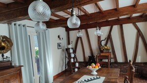 Un comedor rústico con una mesa de madera, un frutero y lámparas de cristal colgantes.