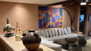 A modern living room with a beige sofa, a glass coffee table, and a decorative bowl. - La Casa Que Ve al Mar te da la bienvenida en 2026! (Zihuatanejo)