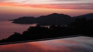 A sunset view over a body of water with distant hills. - La Casa Que Ve al Mar te da la bienvenida en 2026! (Zihuatanejo)