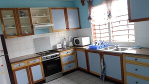 Une cuisine équipée d’une cuisinière, d’un four, d’un four à micro-ondes, d’un évier et de placards.