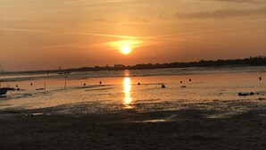 A sunset over a beach with boats and a distant shoreline. - House in Arcachon close to the beach, tastefully decorated, garden (Arcachon)
