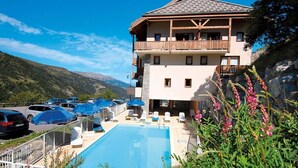 Un hôtel doté d’une piscine, d’un espace extérieur aménagé et offrant une vue sur la montagne.