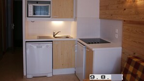 Une cuisine compacte équipée d’un lave-vaisselle, d’un four à micro-ondes, d’une cuisinière et d’un évier.