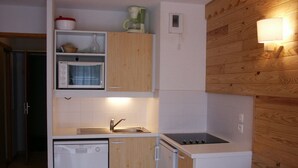 Une cuisine compacte équipée d’un lave-vaisselle, d’un four à micro-ondes, d’une cuisinière et d’un évier.