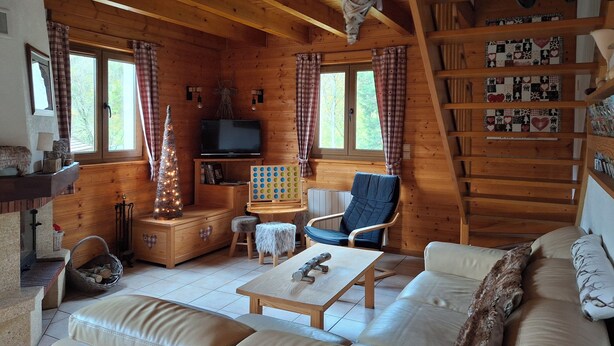 A cozy cabin interior with a wooden interior, a television, a fireplace, and a Christmas tree. - Chalet des Etangs in La Bresse for 8 people (La Bresse)