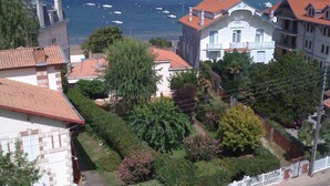 Et kystnært boligområde med huse, et hvidt hegn og havudsigt med både.