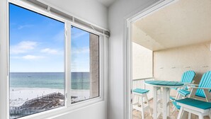 Un balcon avec vue sur la plage et l’océan.