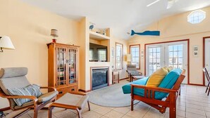 Una sala de estar con chimenea, un aparador de madera, un sofá y una silla.